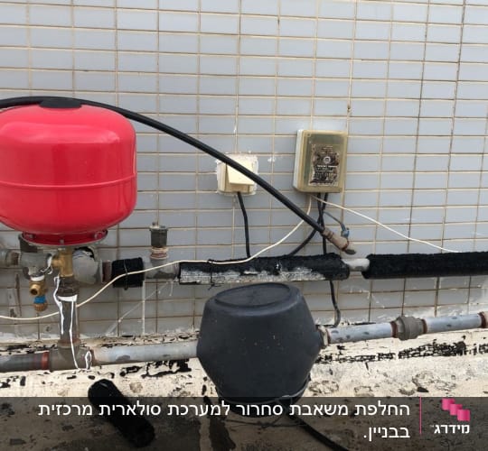 מערכת דודים עם מיכל אדום וצינורות מבודדים